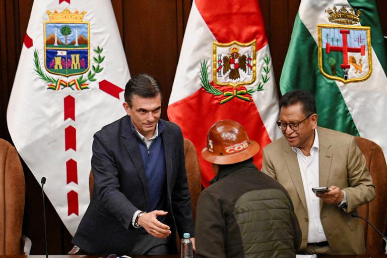 Naslovna slika: Predsednik Bolivije Paz i predstavnik COB-a se rukuju nakon dogovora o prekidu blokada